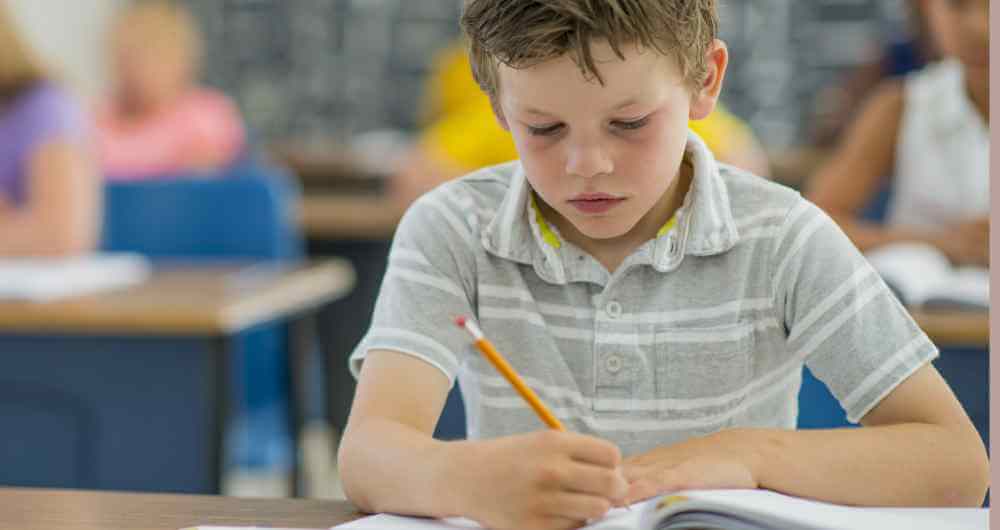 Elementary-age child working on a homework assignment in class.