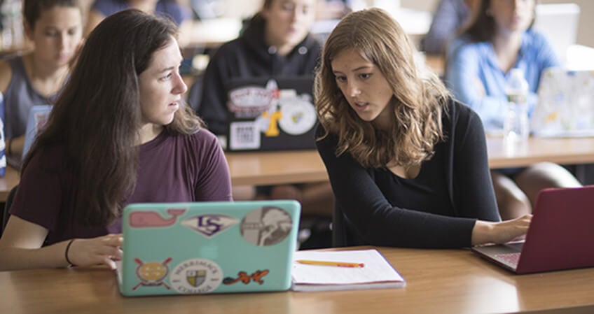 Two female students collaborate in class