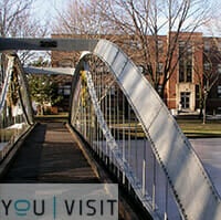 Bridge at Merrimack College with You Visit logo.