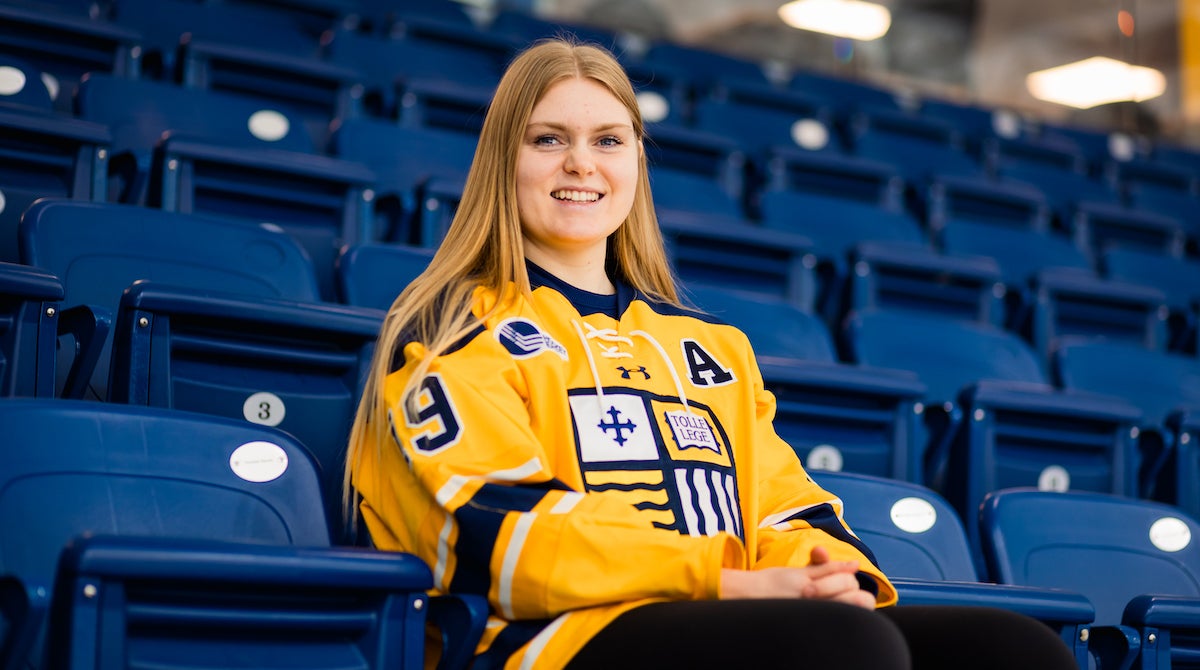 Photo of Raice Szott ’24 sitting in the stands at Lawler Rink.