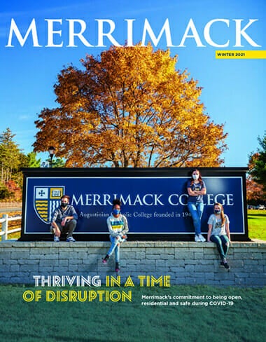 Magazine cover for winter 2021. Students standing in front of the Merrimack College sign.