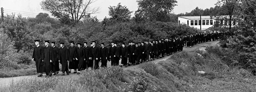 Old photo of Merrimack College students standing in line.