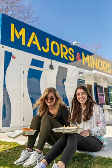 Two students eating outside Majors and Minors eatery