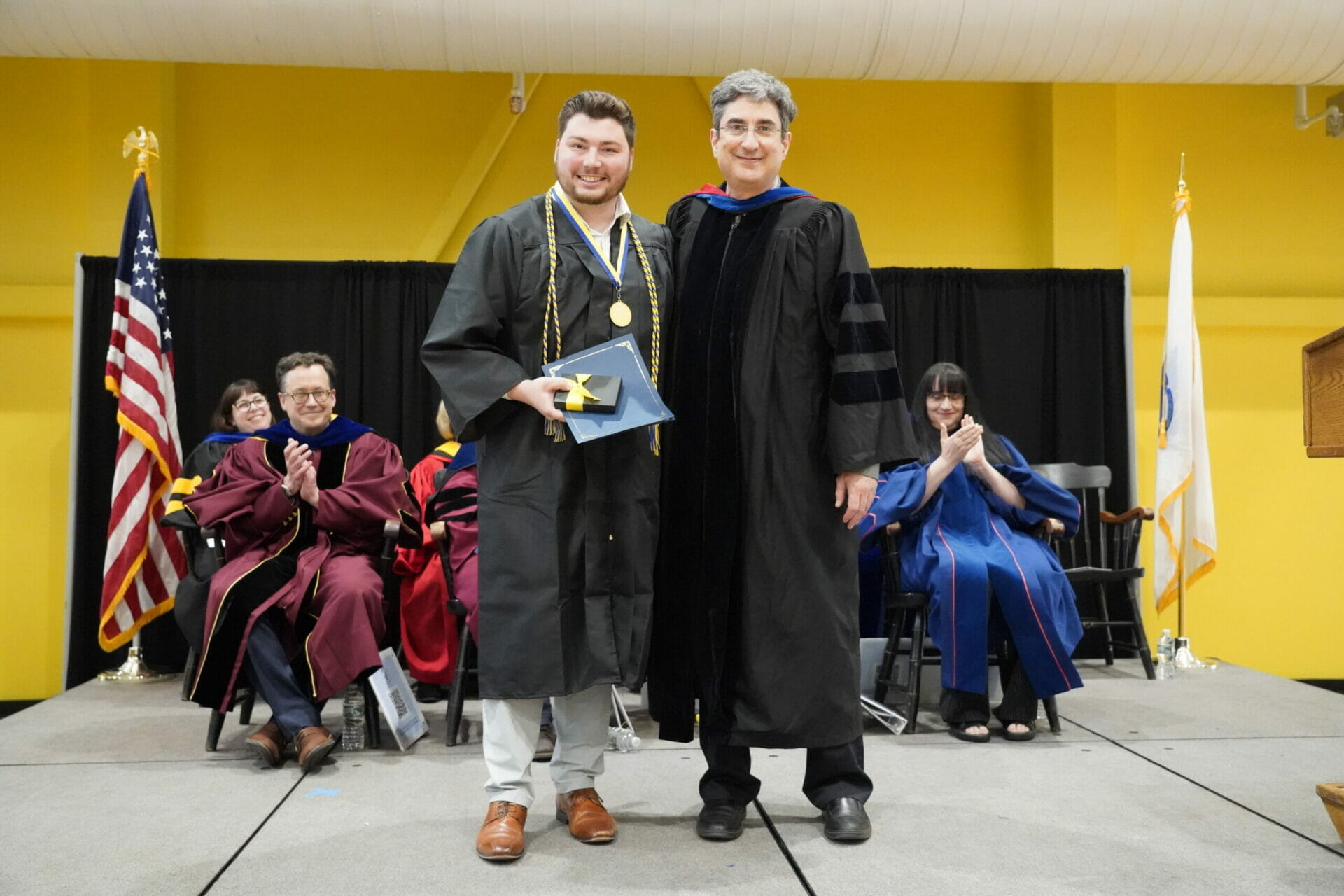 Photo of Nicholas Barber accepting the Merrimack Medal from Provost John “Sean” Condon.