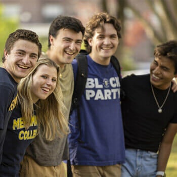 Students smiling with arms around each other