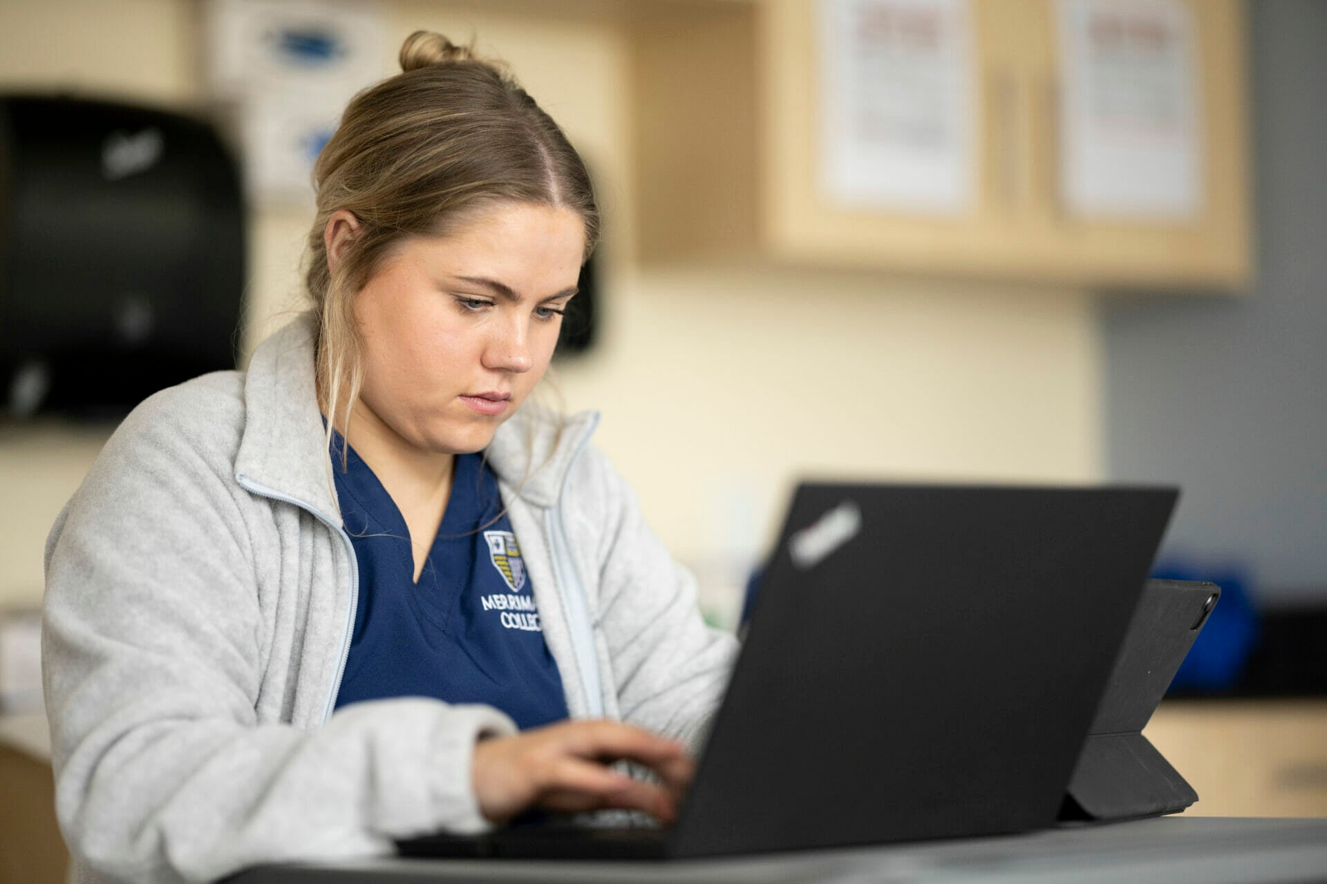 Nursing student researching on laptop.