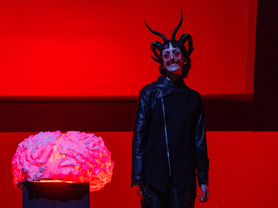 Merrimack Alum Kass Daley as Red Eyes, standing to the right of the brain prop.
