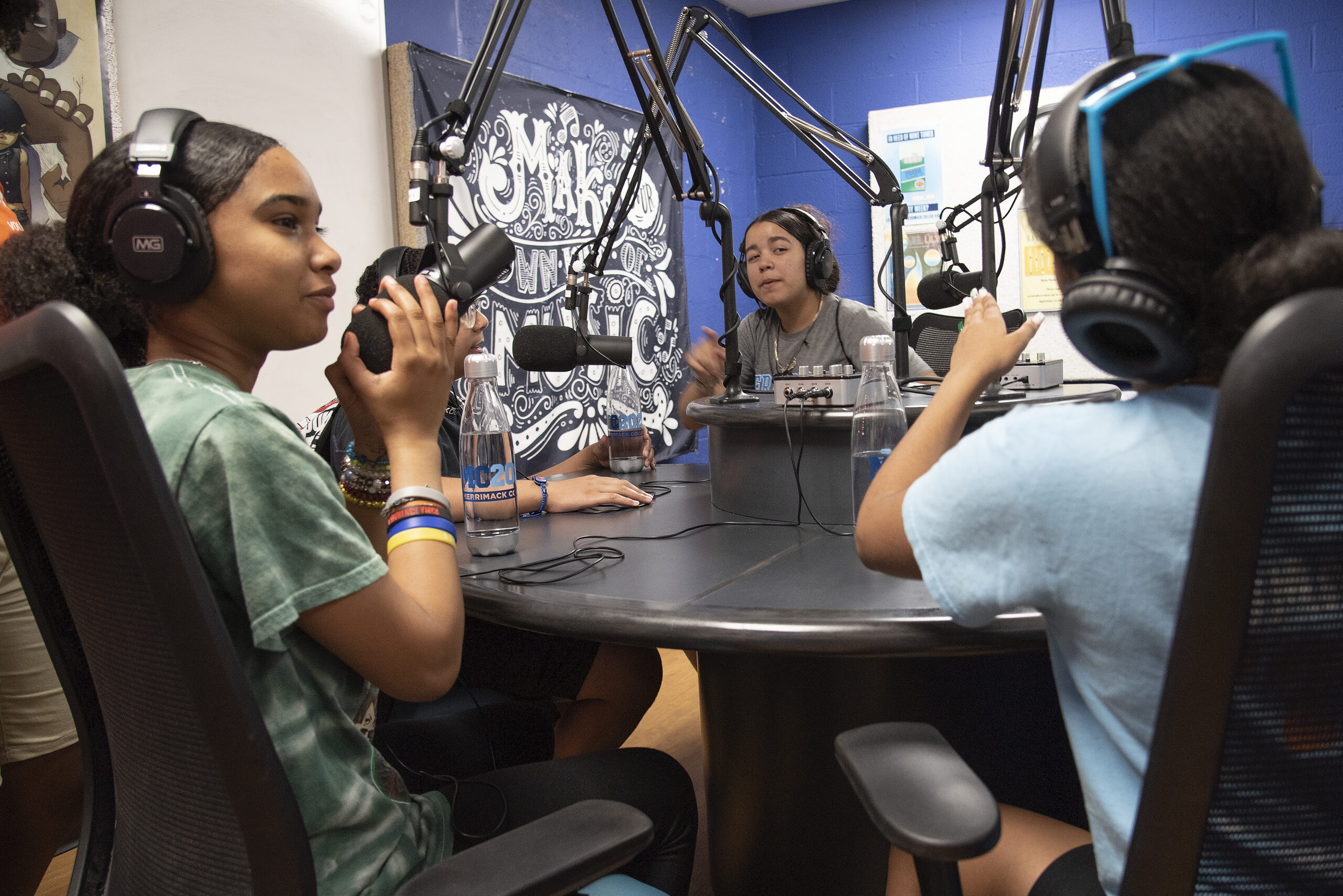 Students using WMCK studio sitting together in front of microphones