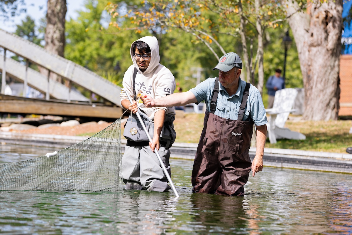 Student and professor in waders standing in body of water