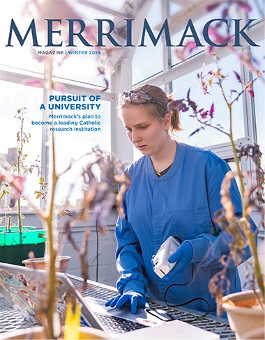 Cover of Merrimack Magazin Winter 2024 featuring student in blue scrubs looking at small trees