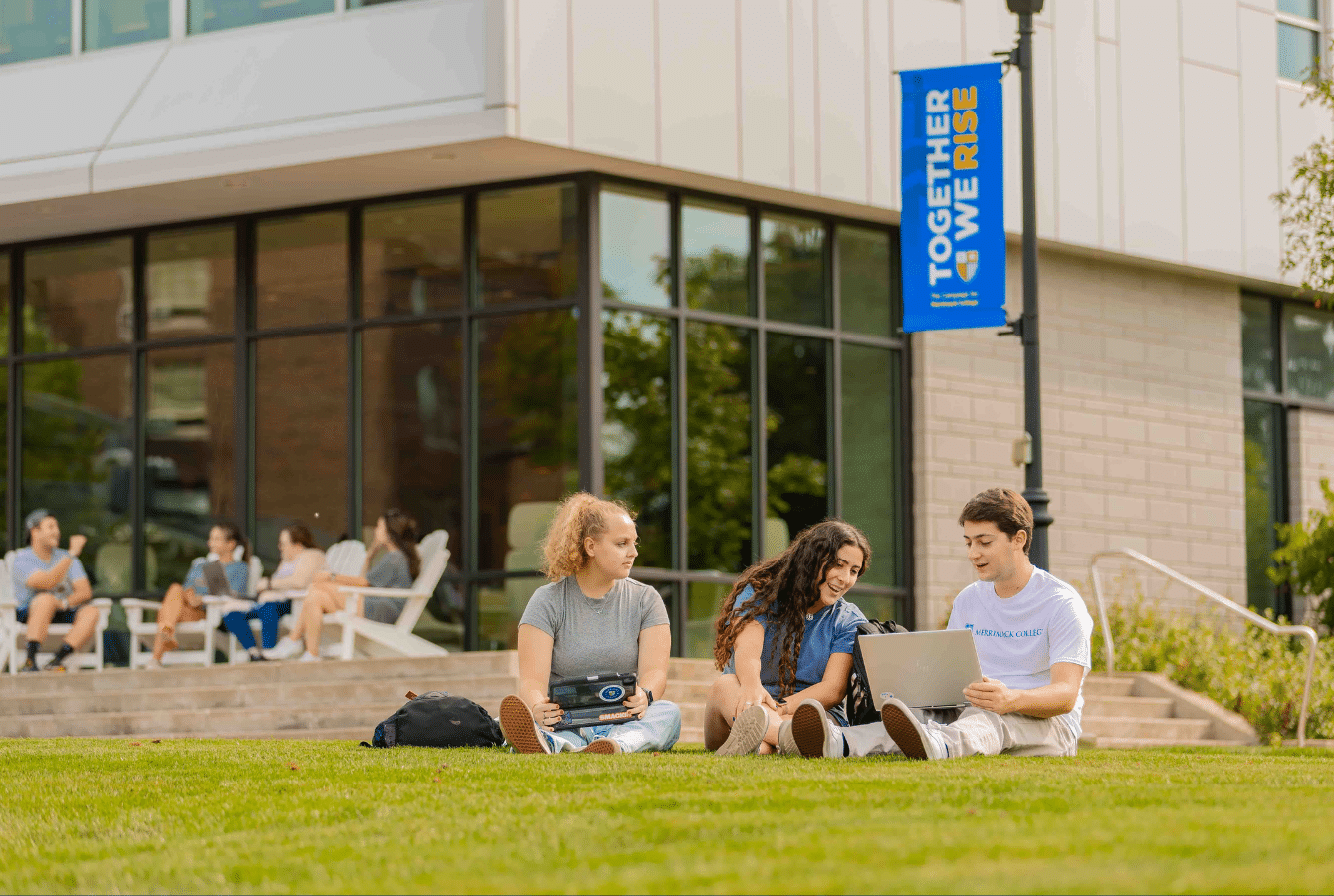 Students sitting on the grass on campus