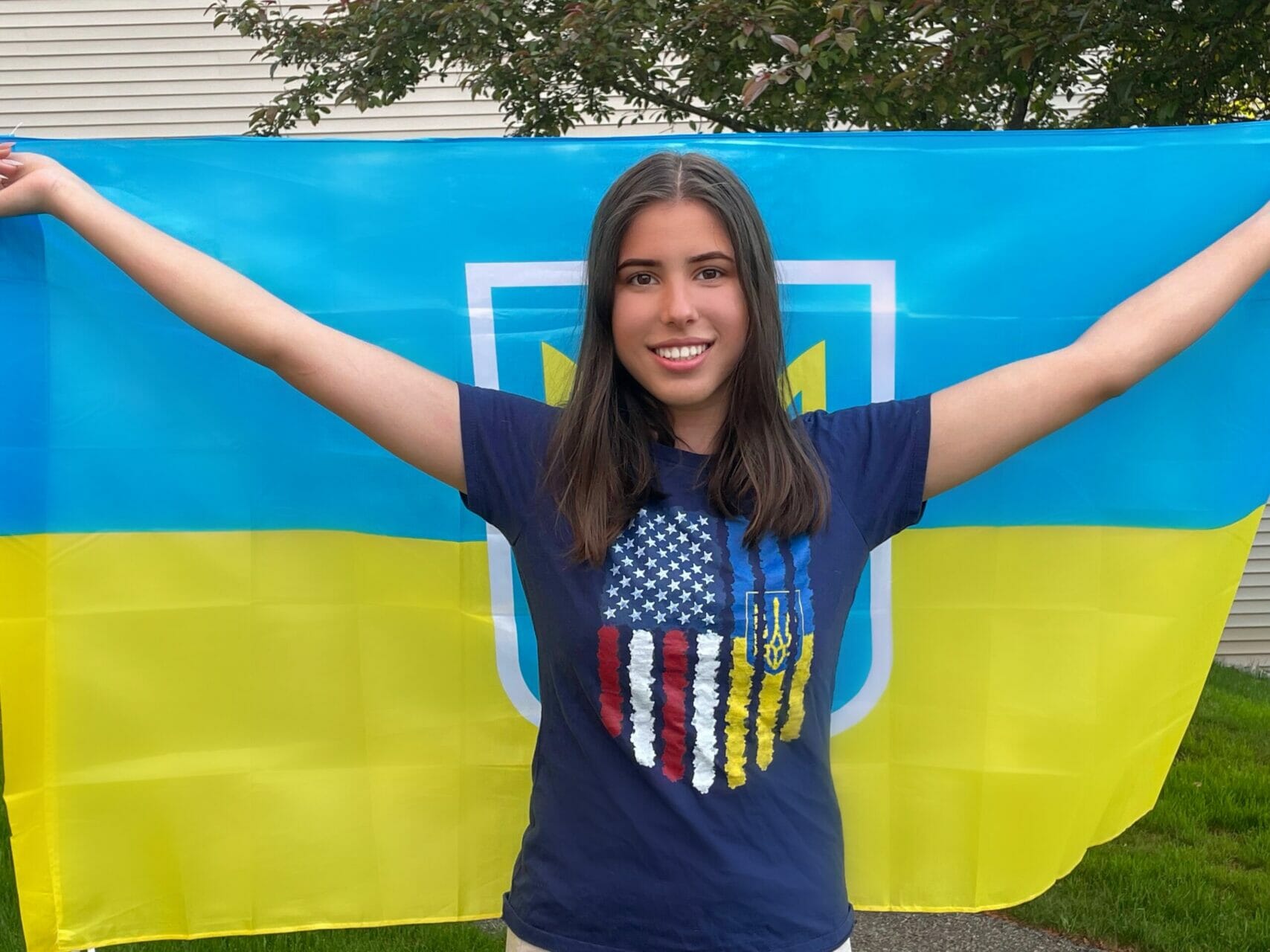 Mariia Diahilieva poses in front of the Ukrainian flag