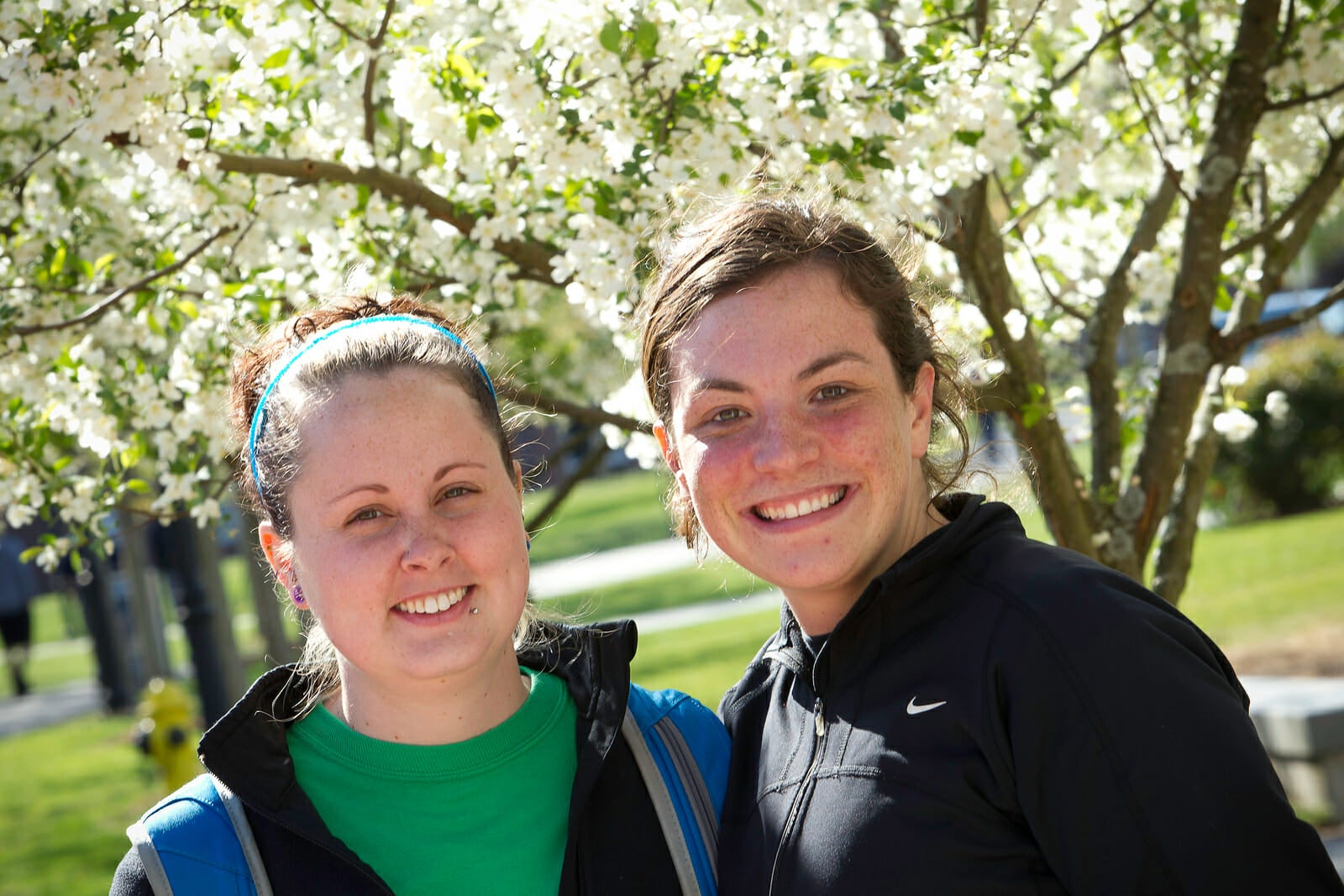 Students smiling in front of flowering dogwood trees