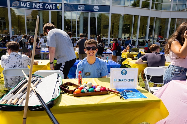 Student sitting at billiards blub info table