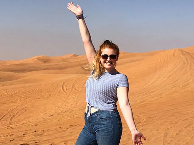 Student with outstretched arms in the desert