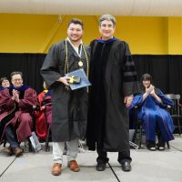 Photo of Nicholas Barber accepting the Merrimack Medal from Provost John “Sean” Condon.