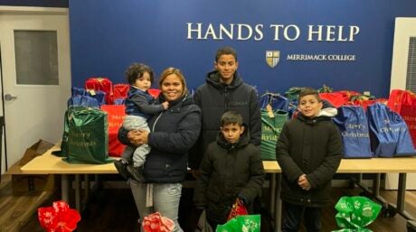 Dahiana Rosario and her family stand with bags of donated holiday toys.