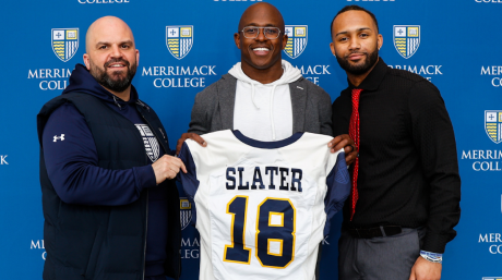 Photo of Merrimack head football coach Mike Gennetti, former Patirots wide receiver Matthew Slater and Grant Jackson ’23, M’24. Slater holds a Merrimack football jersey with his name and number on it.