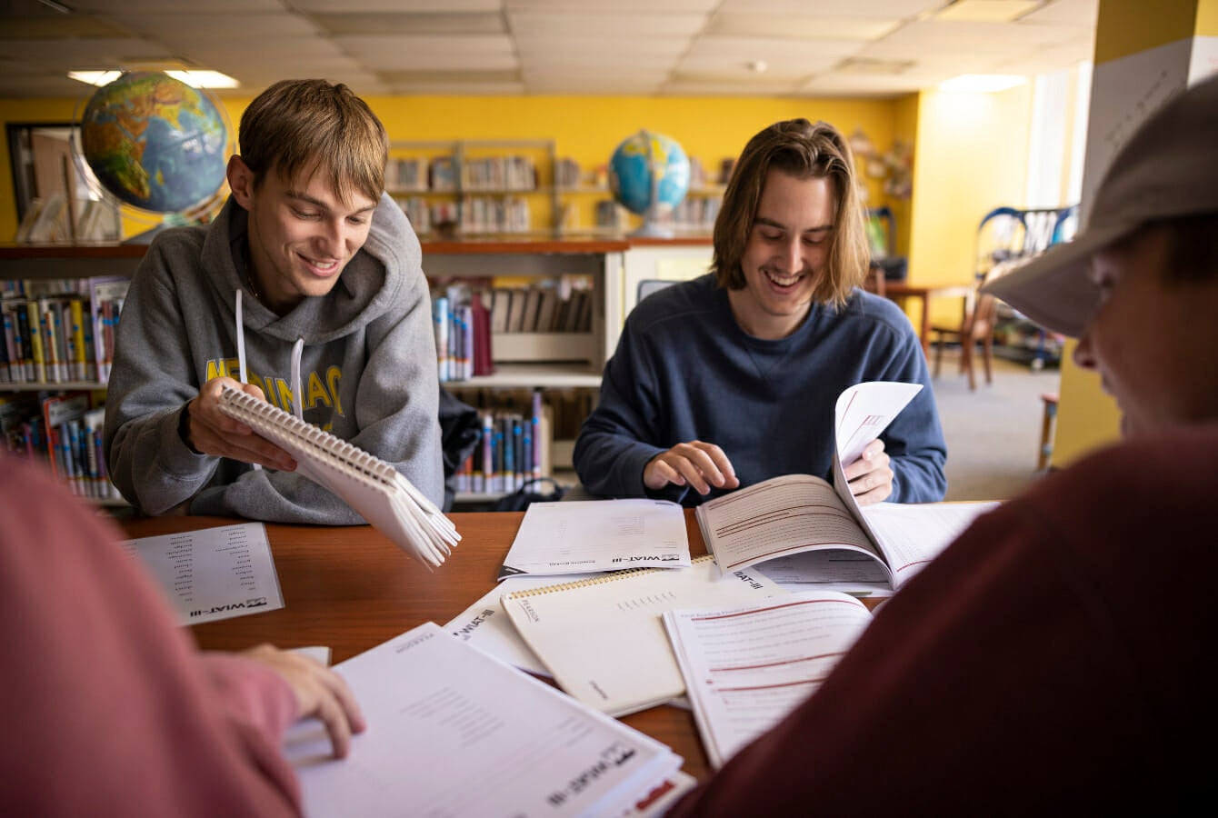 Two students smiling while reviewing notes